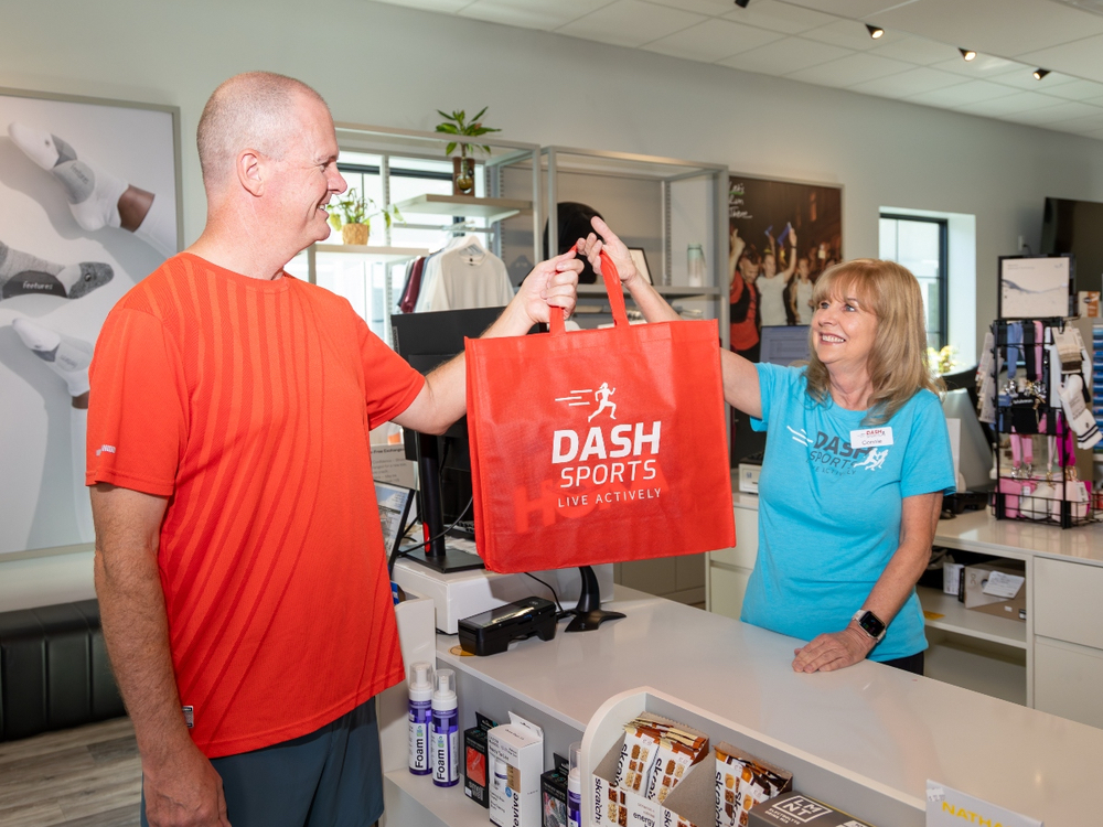 Dash Sports fitter measuring a customer's foot during a complimentary shoe fitting in Clermont, FL