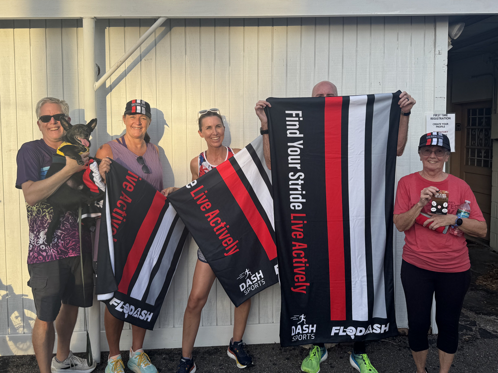 Dash Sports Mileage Challenge runners in 100 Mile Club hats holding FloDash Find Your Stride towels earned in Clermont, FL